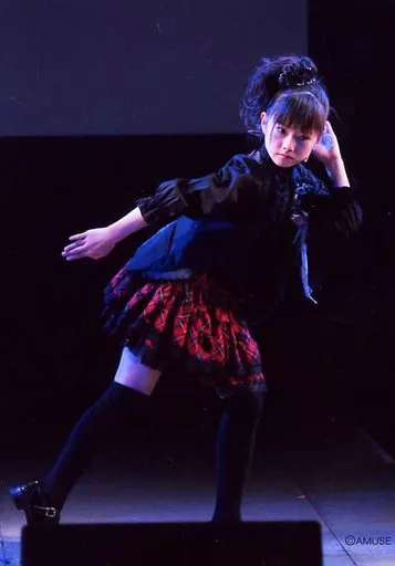 さくら学院(重音部 BABYMETAL)/水野由結/ライブフォト・全身・衣装黒・スカート赤チェック柄・体右向き・左手耳元・体斜め・背景黒/「さくら学院 2011年度 NEW～Departure～ LIVE生写真」