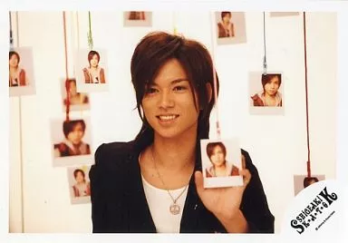 生写真(ジャニーズ)/アイドル/NEWS　NEWS/加藤シゲアキ/横型・バストアップ・ジャケット黒・インナー白・左手上から吊るされた写真・背景白・ロゴ「SHiGEAKi KATO」/公式生写真